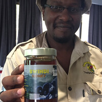 A man holds out a jar of honey